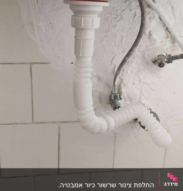 צינור ניקוז לבן מתחת לכיור עם חיבורים